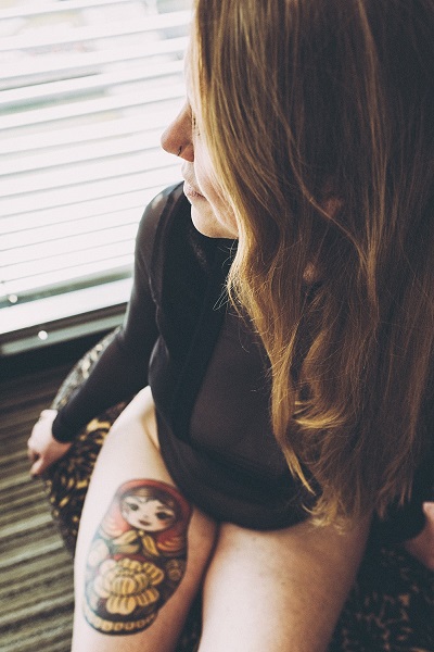 Helena looking right in black body sitting by a window